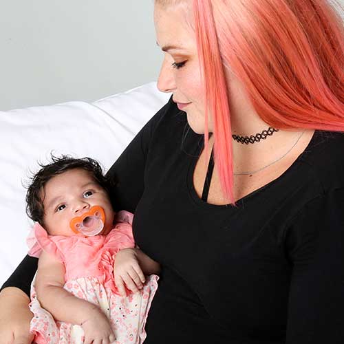 young woman holding baby in lap