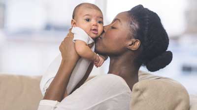 Young mother holding up newborn